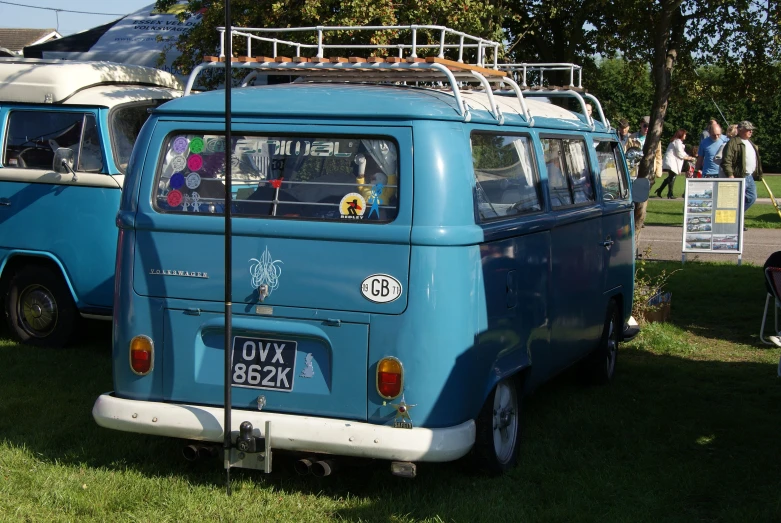 people are gathered around an old vw bus at a festival