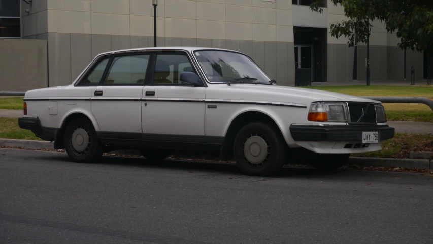 a white car is parked in front of a parking meter