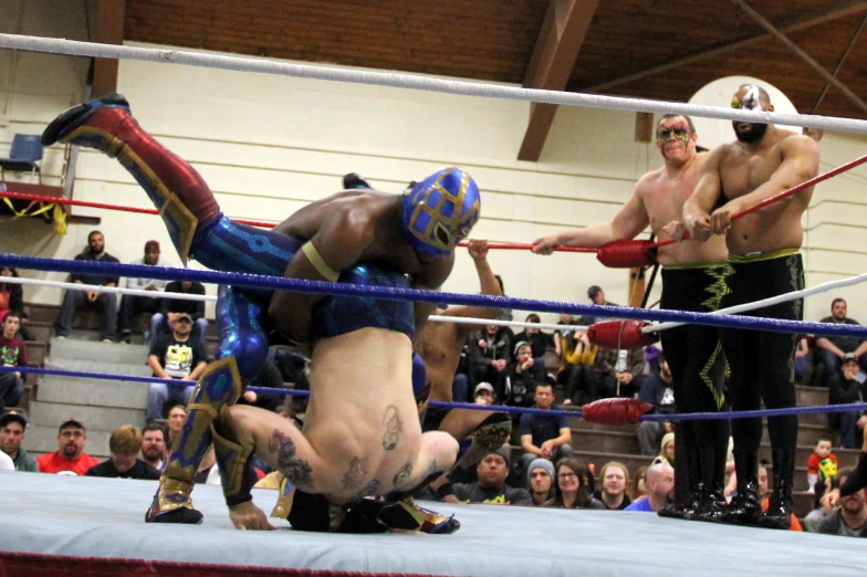 two wrestlers compete in a ring in front of fans