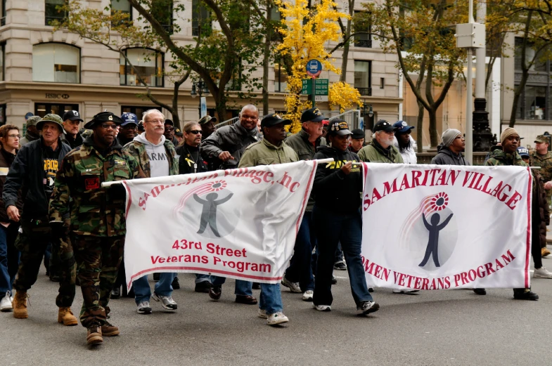 people hold a banner with images of the military