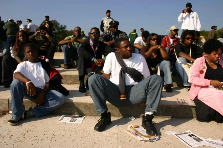 young black people sitting on steps and watching others