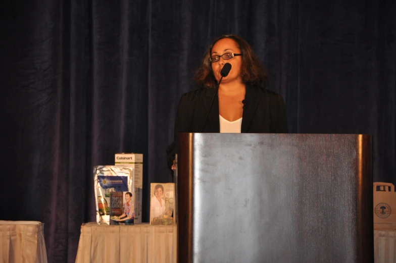 a woman is speaking at a podium