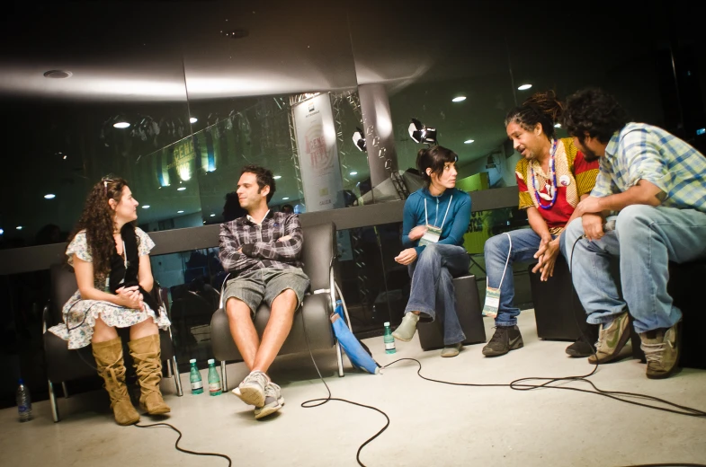 four people are sitting on the floor listening to music