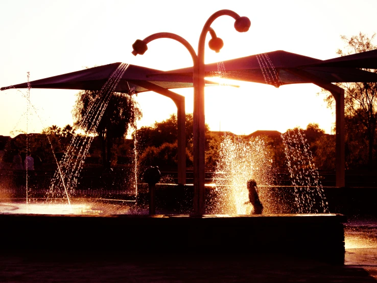 a couple walking away from the park with a beautiful fountain in front