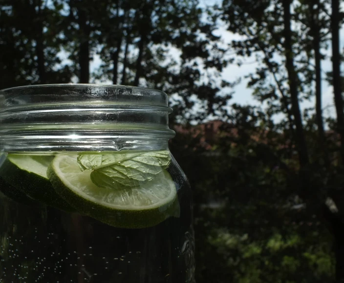 a jar filled with water and lime slices