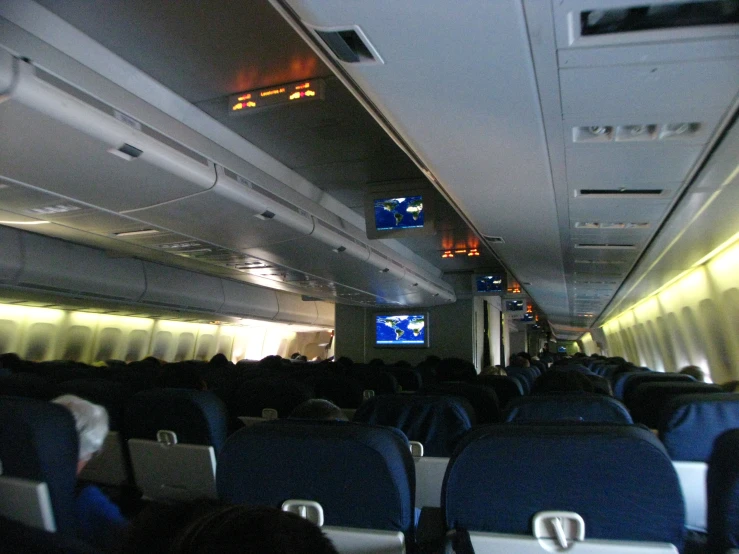 the inside of an airplane with rows of empty seats