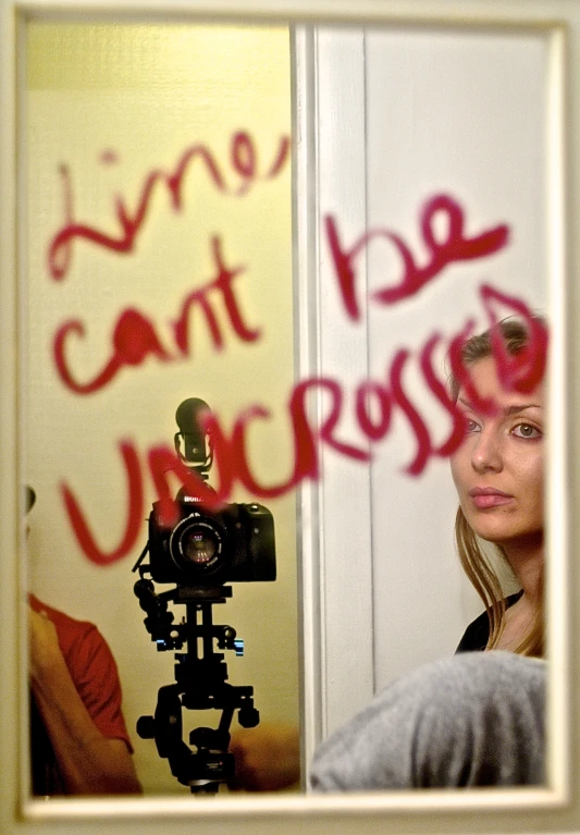 a woman behind a door taking a po with her camera