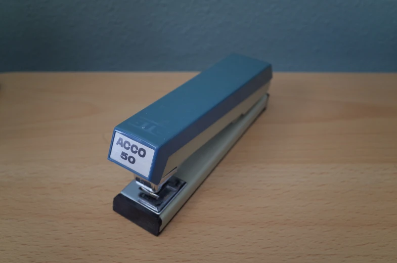 a stapler sitting on a wooden surface