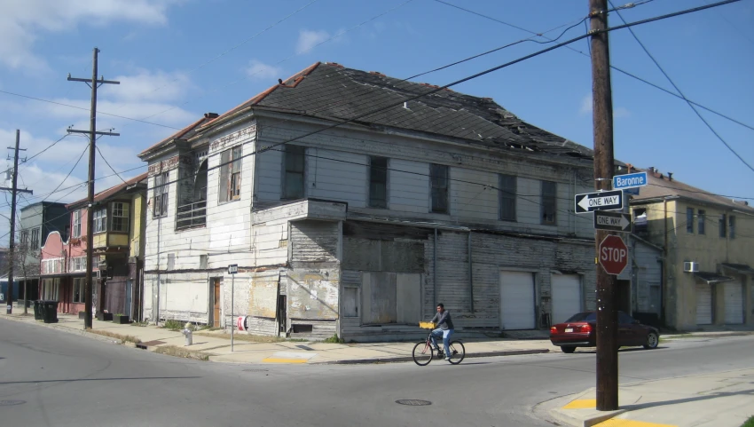 an old run down building with a bicycle parked on the curb