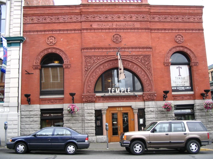 two cars parked on the sidewalk outside of a building