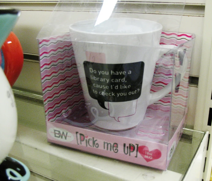 a coffee mug sitting on top of a pink box