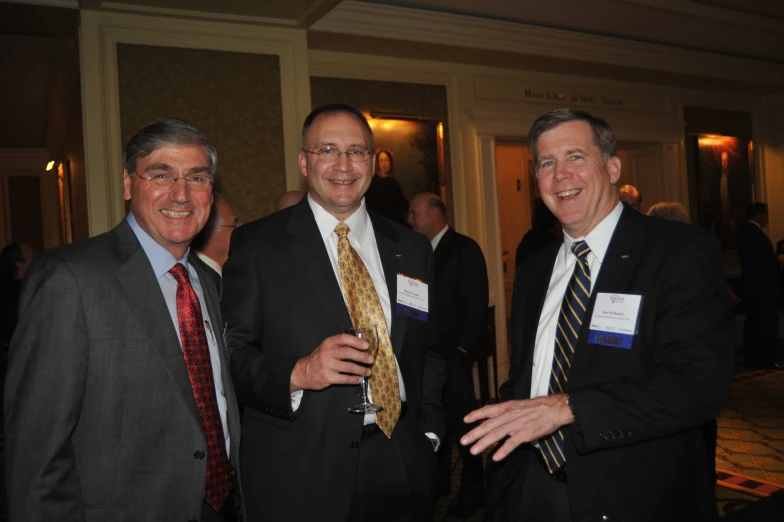 three men in suits are posing for the camera