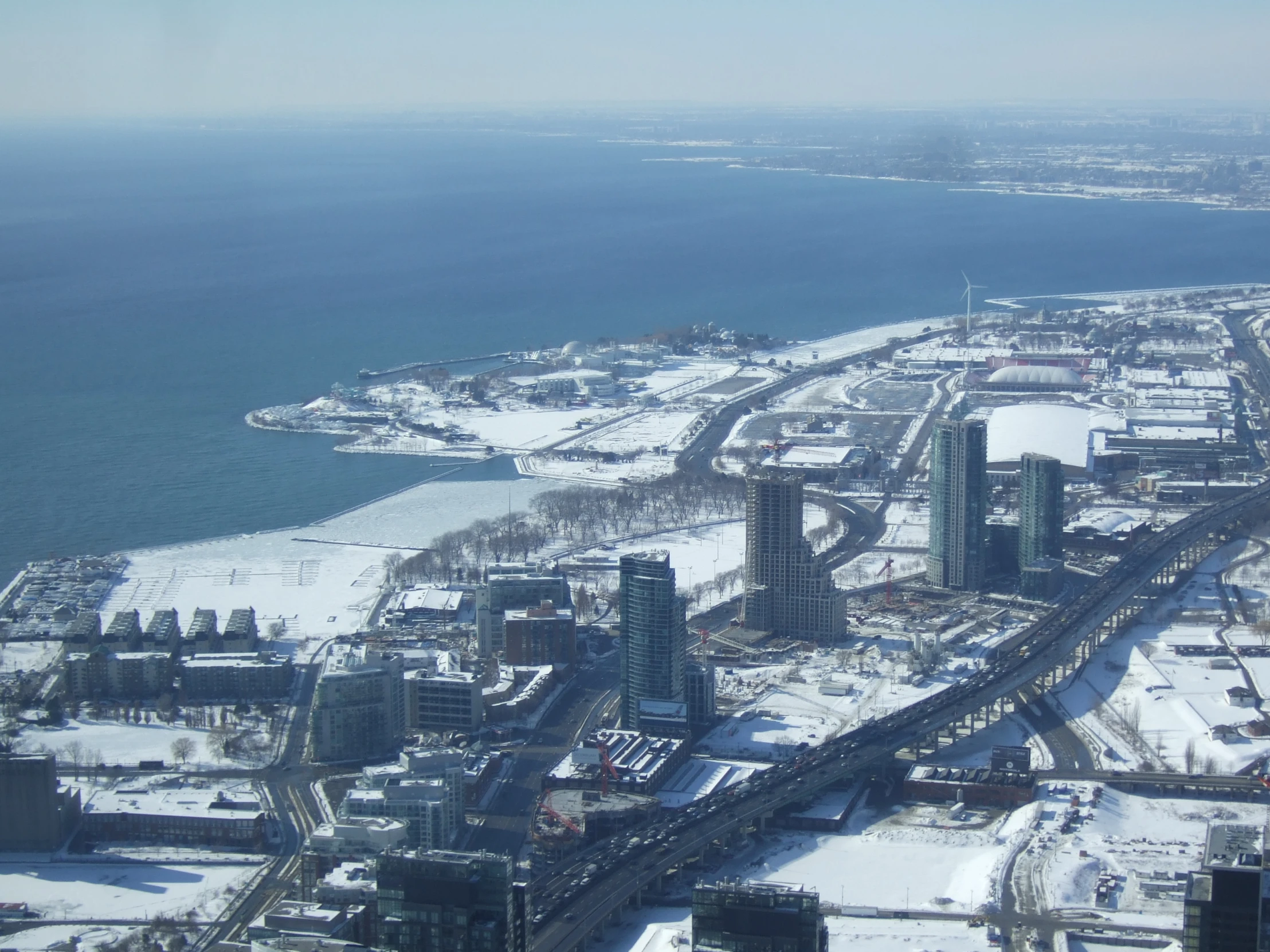 snow covered snow covered city and road by ocean