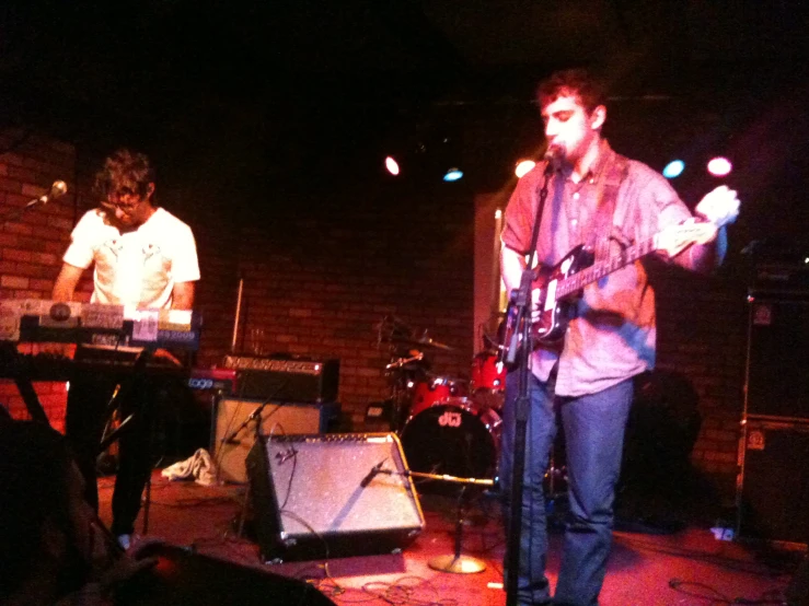 two men on stage playing instruments and singing