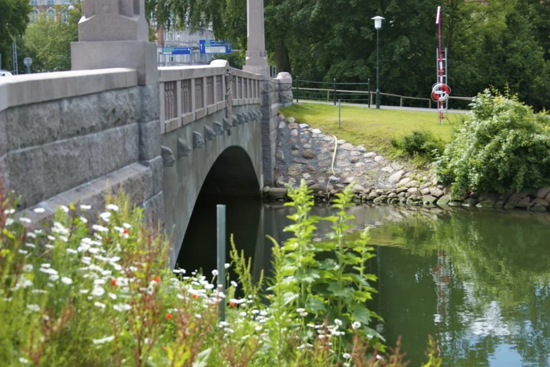 bridge above water on a sunny day near green grass