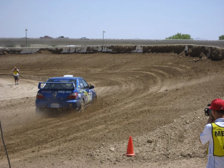 a man driving in the mud behind a car