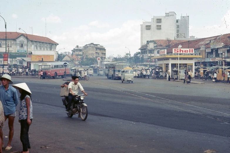 three people on a motorcycle going down the road