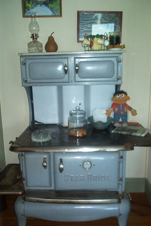 an old fashioned metal stove with a little toy on it's burner