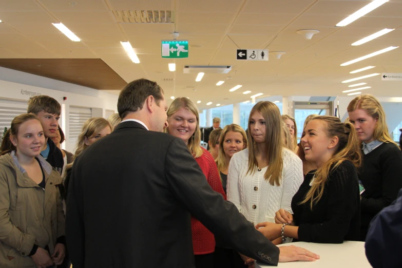 two men greeting a crowd of people in an office