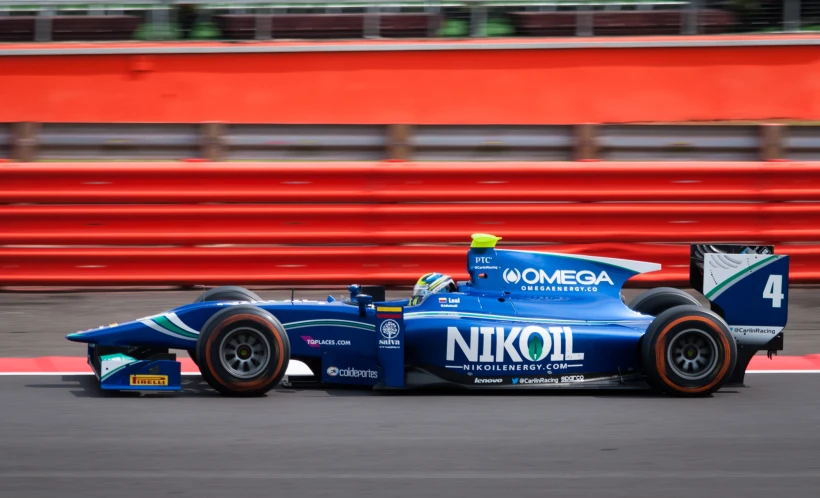 an athlete driving a blue race car on the track