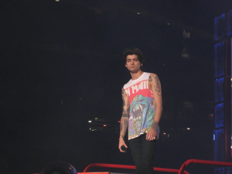 man with tattoos on his arms stands in front of the audience