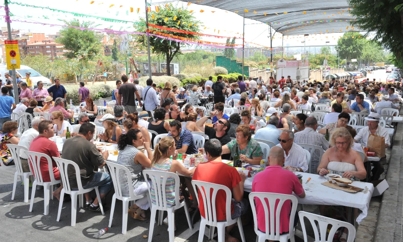 a large group of people sitting outside at tables