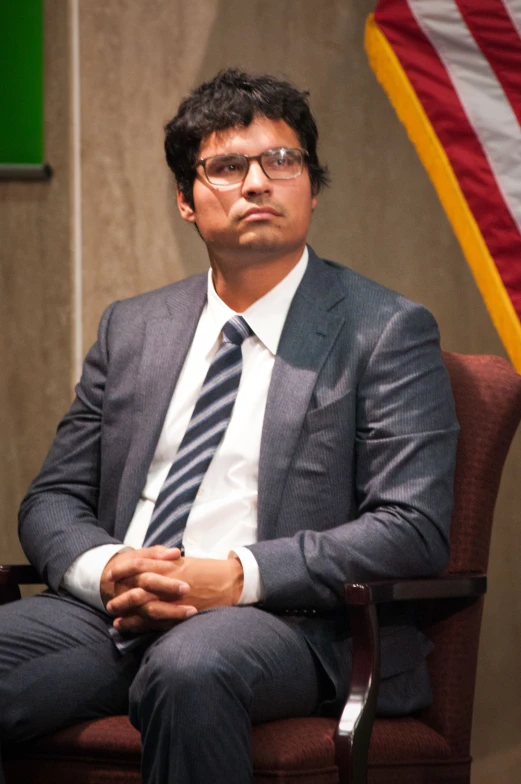 a man in a suit and tie is sitting down