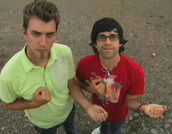 a man standing next to another person in a parking lot