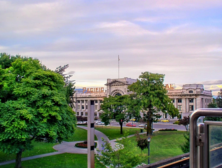 a scenic view of a city street, park and railroad tracks