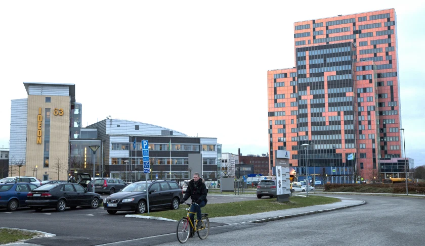 a person riding a bike past a lot of tall buildings