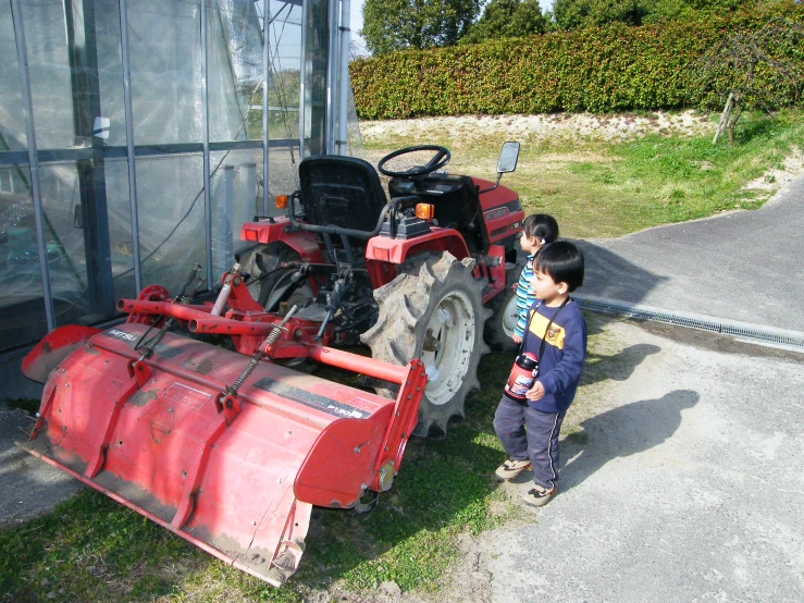 the  is standing next to the large tractor