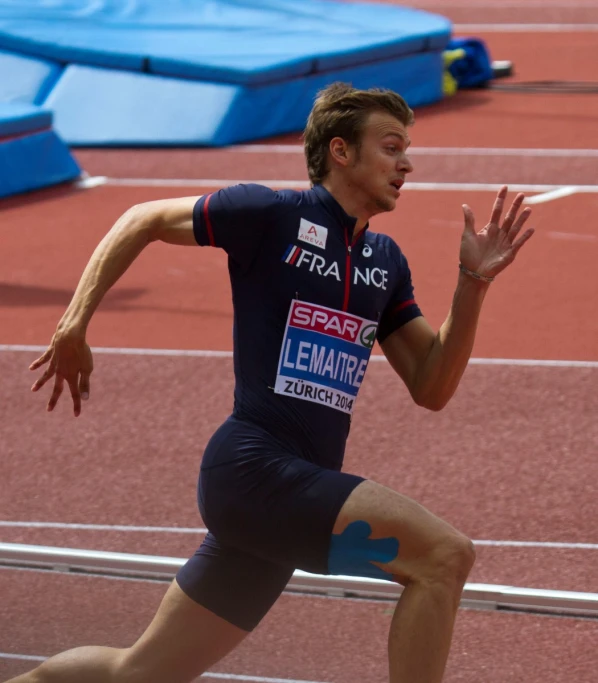 a man running down the track with his hands out