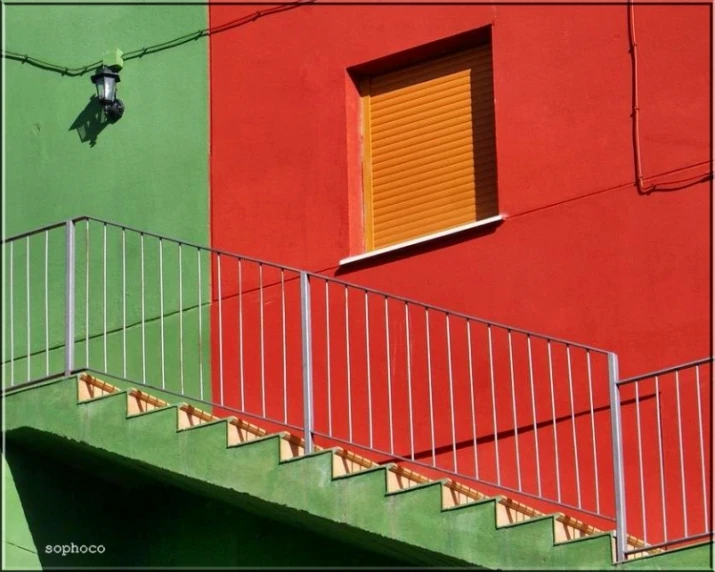 a red staircase leads up to an open yellow door