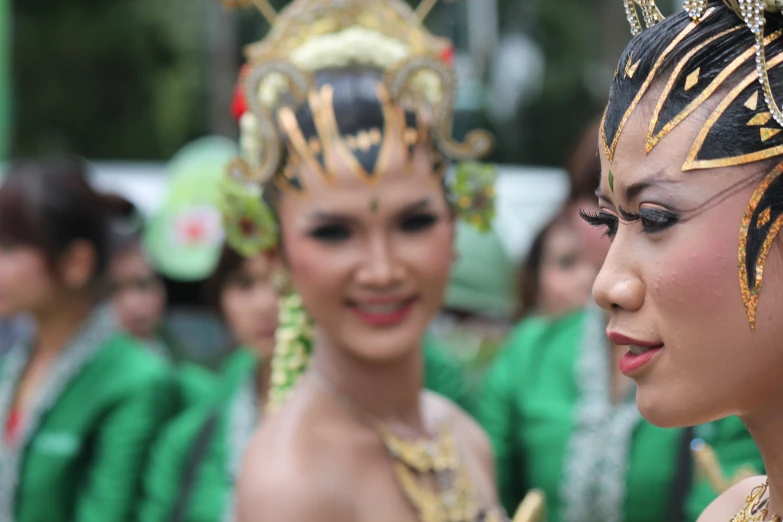 two women in elaborate head dress with gold accents