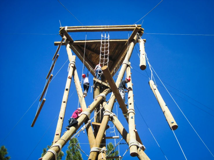 a tall wooden structure with ropes going up and down the side