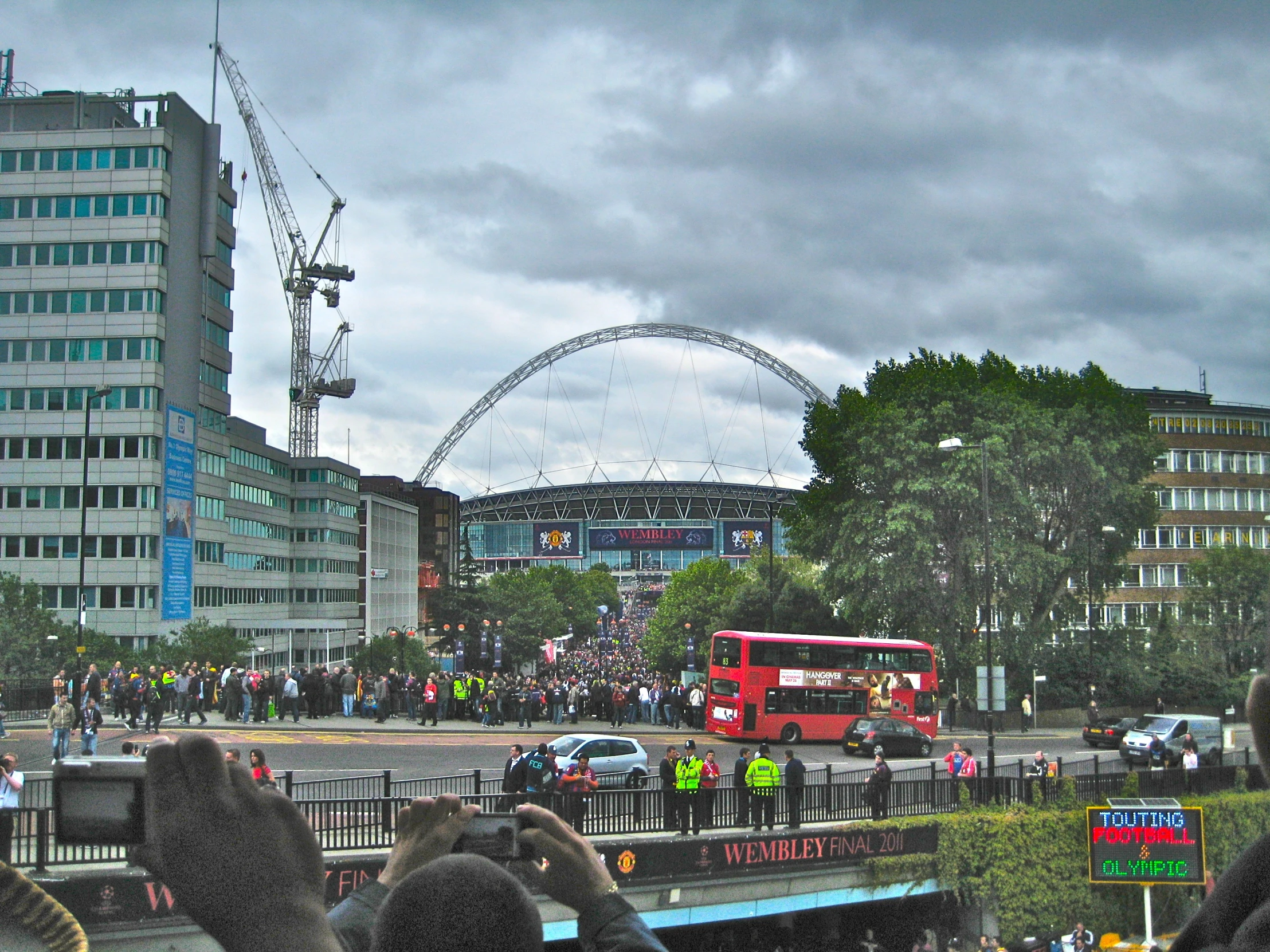 the crowd looks on as a bus passes by