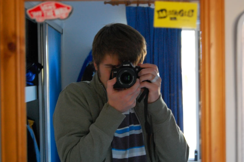 a young man taking a po in a mirror