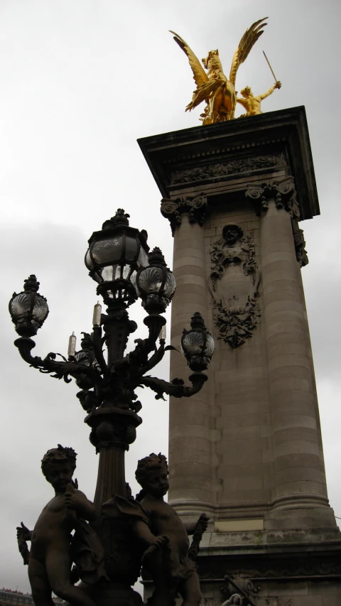 the ornate lamp post has a golden statue on top