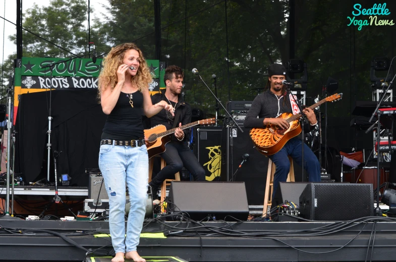 a woman standing on top of a stage while singing into a microphone