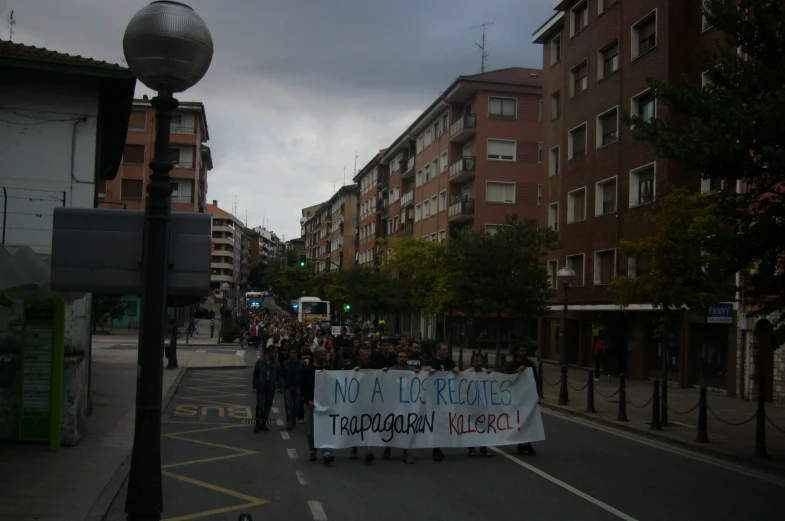 several people carrying a banner down a crowded street