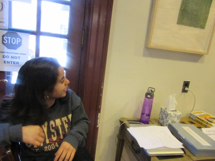 a woman sitting down in a chair talking to another woman