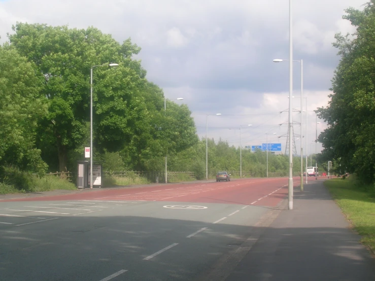 a stop light on a busy street in front of lots of trees