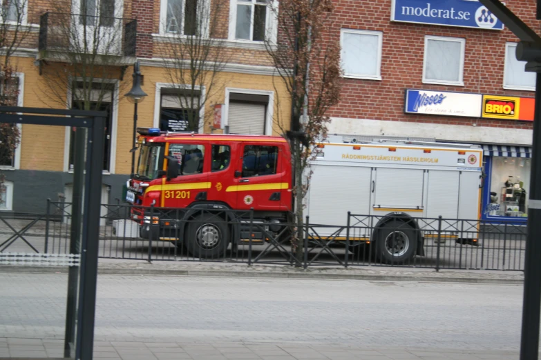 a red work truck is parked near a building