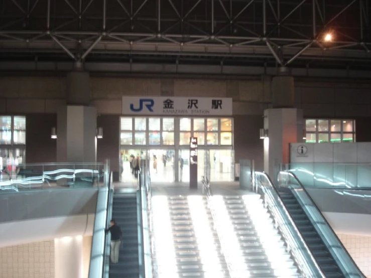 a po of people going down the escalator in a station