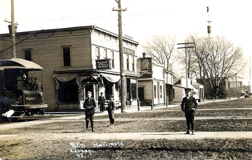 people walk through a town near an old train