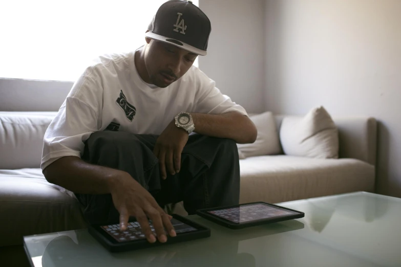 a man sitting on a couch with his hand on a tablet