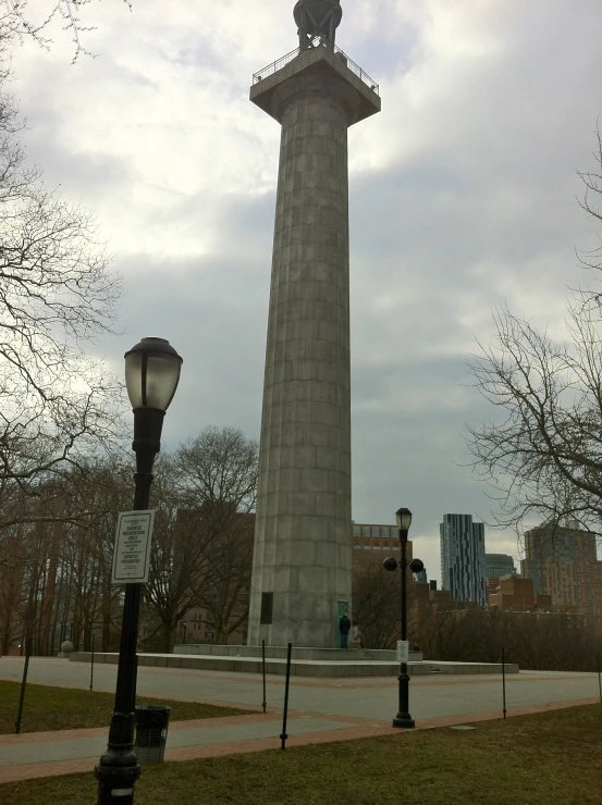 a large monument with a statue on top sits in a grassy park