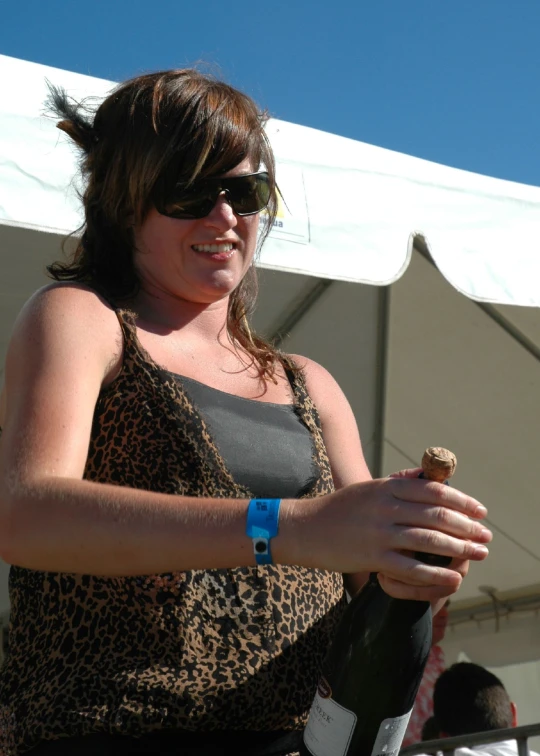 woman in black sunglasses holding a bottle of wine