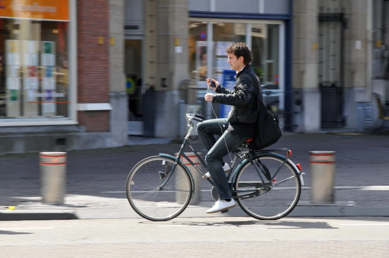 man with bag riding a bicycle and texting