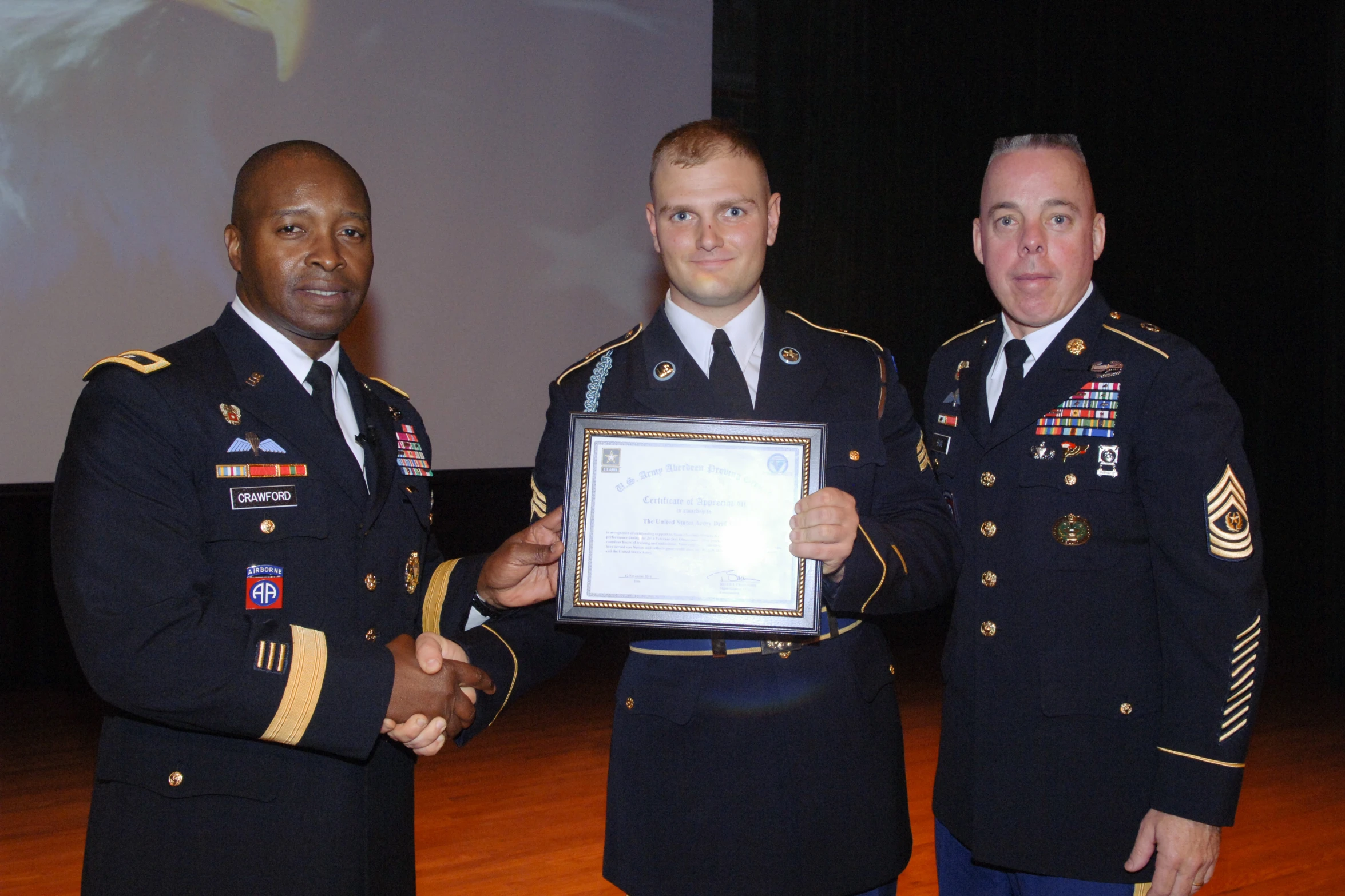 the men in uniform are standing in front of a projector screen